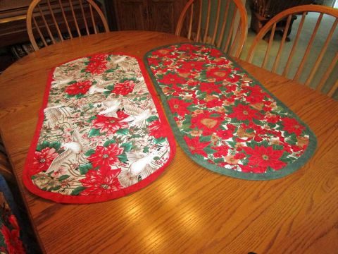 Two table toppers unquilted – 18” x 40” Large Christmas prints – one trimmedIn red and one in green.